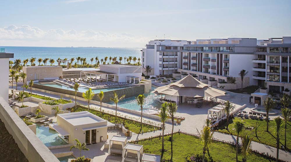 Pool and palm trees at Majestic Elegance Costa Mujeres